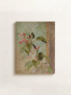 A rectangular canvas wall art print featuring a vintage-style painting of pink blossoms and green leaves on a textured beige and muted blue background, displayed against a light off-white wall.