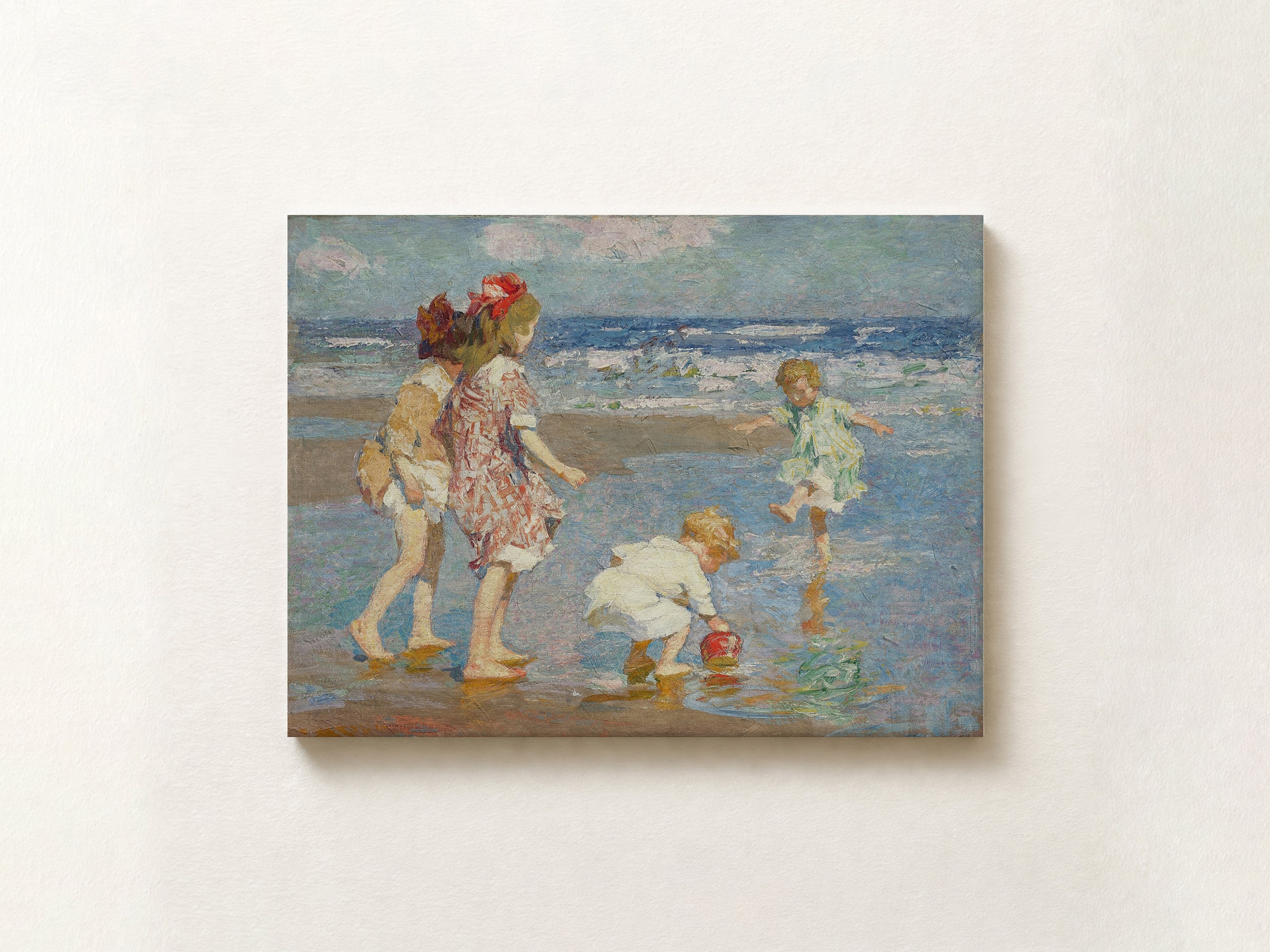 An impressionist-style painting of children playing on a beach, shown as a rectangular canvas mounted on a light beige wall.