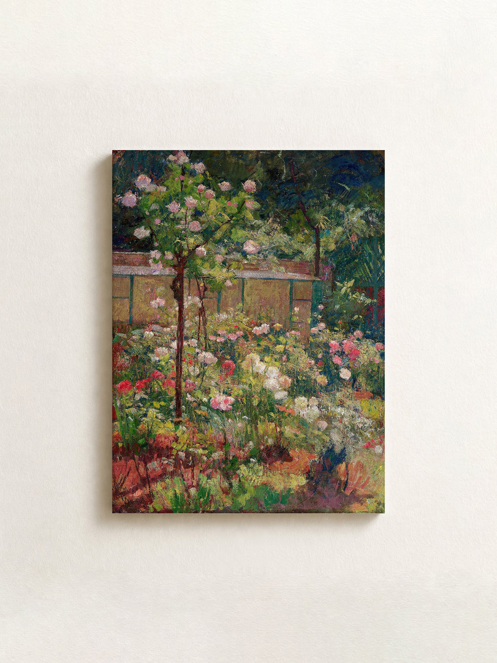 An impressionist-style floral painting on canvas, depicting dense green foliage, pink and white blossoms, and a rustic wooden structure, displayed against a light beige wall.