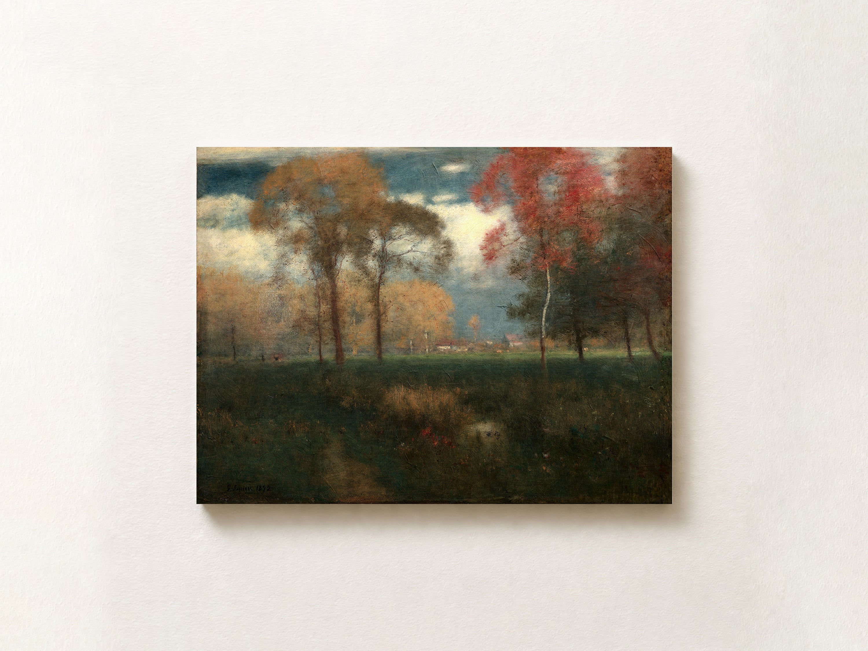 A horizontal landscape painting of an autumn field with trees in shades of red, orange, and green under a cloudy sky, displayed on a textured off-white wall.