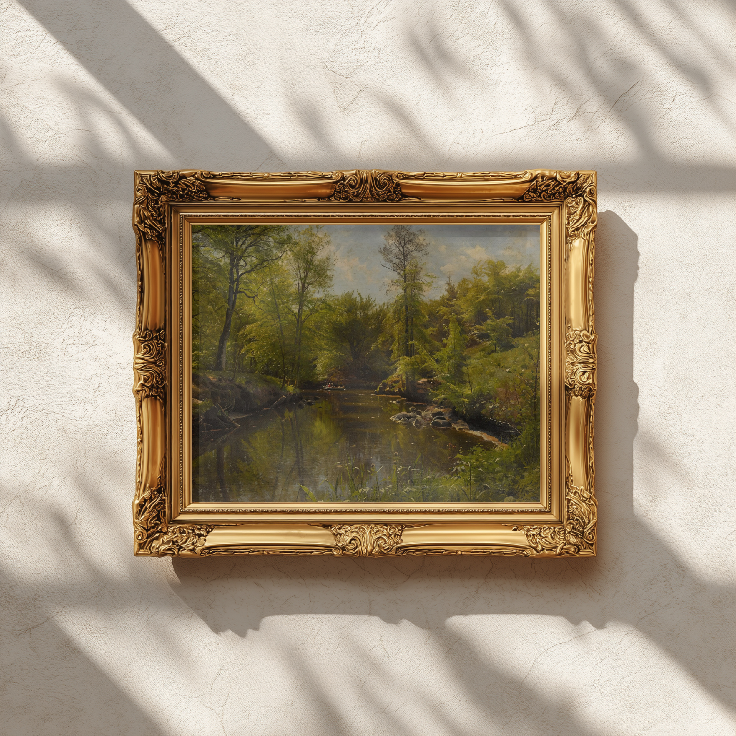 An ornate gold picture frame holding a landscape painting of a forest, mounted on a textured off-white wall with soft leaf shadows cast across it.