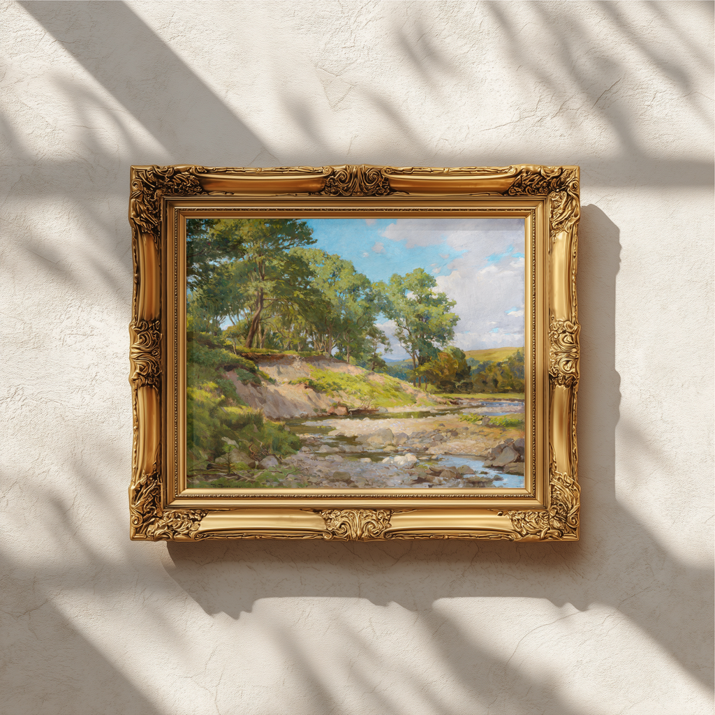 An ornate gold picture frame holding a landscape painting with green trees, a river, and blue sky, mounted on a textured white wall with dappled sunlight and shadows.