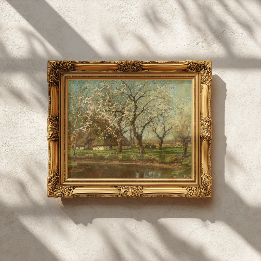An ornate gold picture frame containing a landscape painting of blooming trees, mounted on a textured white wall with soft window shadow patterns.
