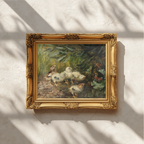 An ornate gold-framed painting of several white chicks gathered in a green, earthy setting, mounted on a textured off-white wall with soft window shadow patterns.