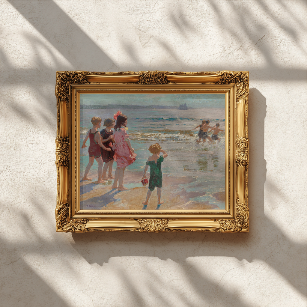 An ornate gold-framed painting depicting children playing on a beach, hung on a textured off-white wall with soft leaf shadows cast across it.