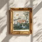 A framed impressionist landscape painting hangs on a textured off-white wall, casting soft shadows from nearby foliage. The painting depicts a harbor scene with boats, figures, and a tree, enclosed in an ornate gold frame.
