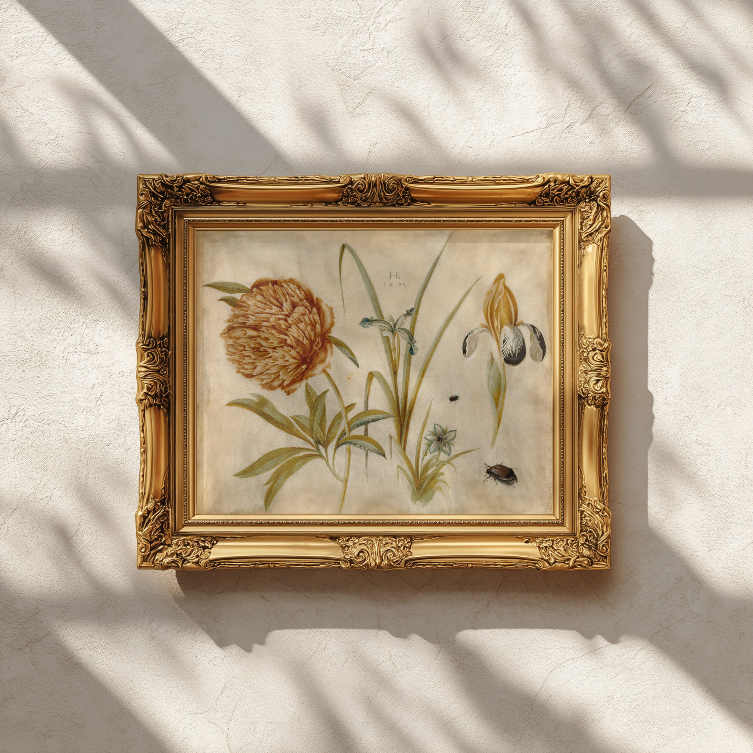 An ornate gold-framed botanical art print featuring a detailed illustration of a large orange-brown flower with green leaves, displayed on a textured off-white wall with soft window shadow patterns.