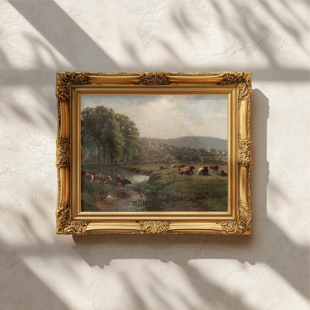 An ornate gold picture frame holding a landscape painting, mounted on a textured off-white wall with soft window shadow patterns.