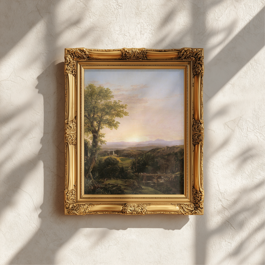 An ornate gold picture frame holding a landscape painting, mounted on a textured white wall with soft shadows cast across it.